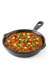 Traditional mexican tex mex chili con carne in a frying pan isolated on white background

