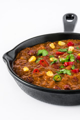 Traditional mexican tex mex chili con carne in a frying pan isolated on white background

