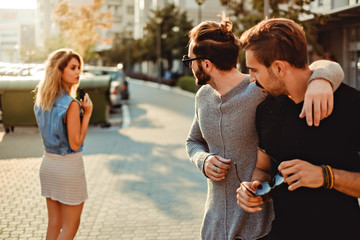 Male friends looking at the girl in the street