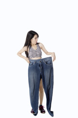 Healthy woman holds large jeans