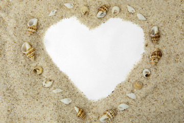 Heart shape on sand with seashells