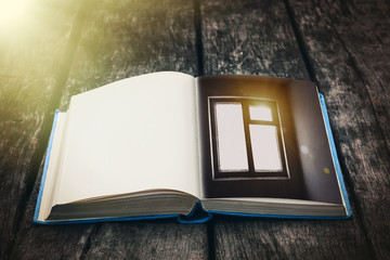 Old open book on a wooden table. Vintage composition. Ancient library. Antique literature. Fabulous atmosphere. Medieval and mystical background, retro style, religion. Close up view.
