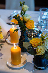 Obraz na płótnie Canvas Beautifully decorated wedding table with yellow roses and candles