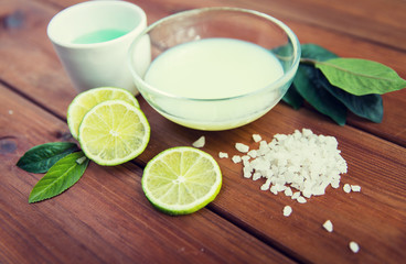 close up of body lotion, cream and salt on wood