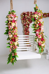 swing with flowers in the white decorations