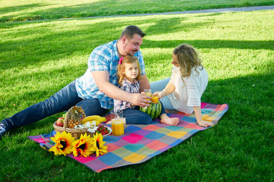 Young family have picknic in a park.