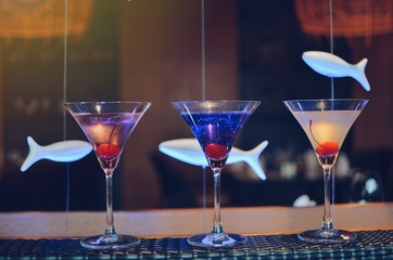 cocktail in martini glasses in front of the night club bokeh lights. Party and celebrate concept 