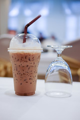 Cold coffee with ice in take away cup in the conference room