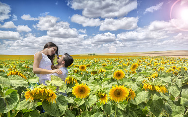 Fototapeta na wymiar Couple of lovers in field of Sunflowers