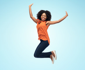 happy african american woman jumping over white