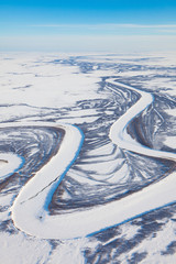 River in winter tundra from above