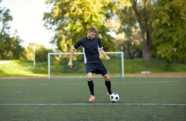 soccer player playing with ball on football field