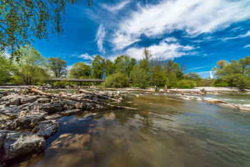 Naherholungsgebiet Flaucher und Flauchersteg an der Isar in München unter weiß-blauem Himmel