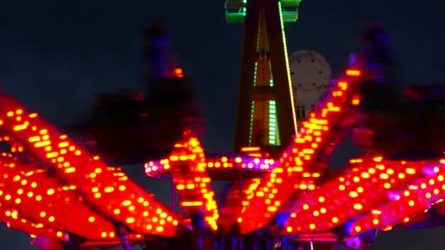 Close-up of attractions of fair, with colored flashing lights and turning at night.Time Lapse.