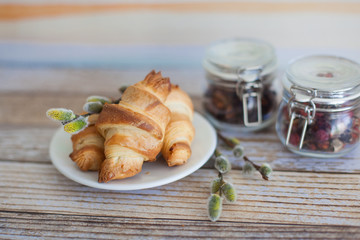 Tasty croissants with spikelets on grey wooden background