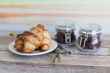 Tasty croissants with spikelets on grey wooden background