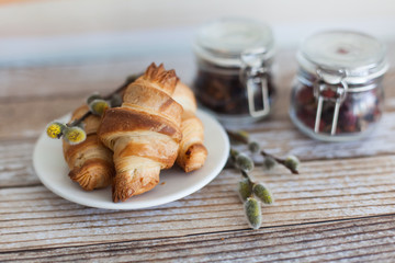 Tasty croissants with spikelets on grey wooden background