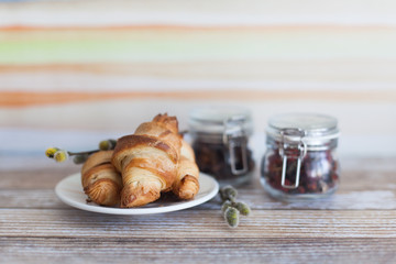 Tasty croissants with spikelets on grey wooden background