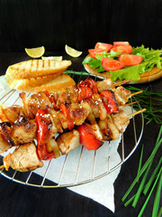 Cooked shashlik made of meat with vegetables lying on the lattice grill