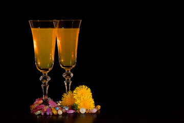 Wine from dandelions in glasses. Black background. Space for text