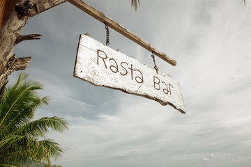 close up view of beach bar logo painted on wooden surface