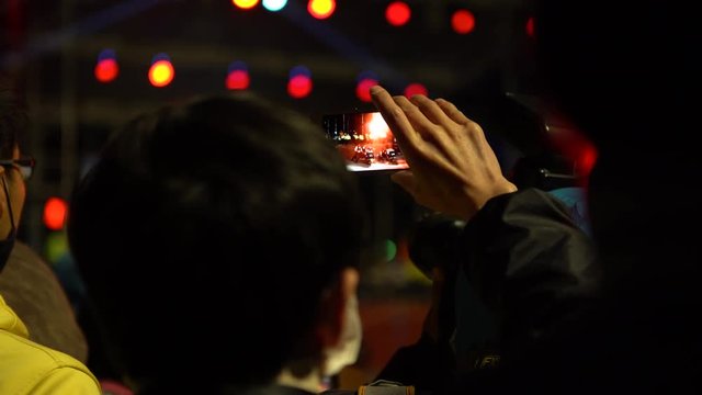 4K Asian spectator using smartphone for take a video with camera phone of the dancing Dragon in Chinese New Year Celebration at Miaoli. Festival of Hakka Dragon Bombing Dance in Taiwan-Dan