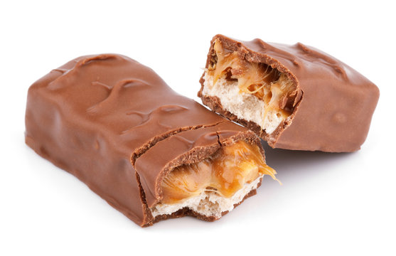 Closeup of broken chocolate bar (nougat topped with caramel, enrobed in milk chocolate) isolated on white background