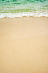 Fototapeta na wymiar summer background of blue wave on the sandy beach