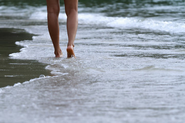 Close up of feet walking on the beach