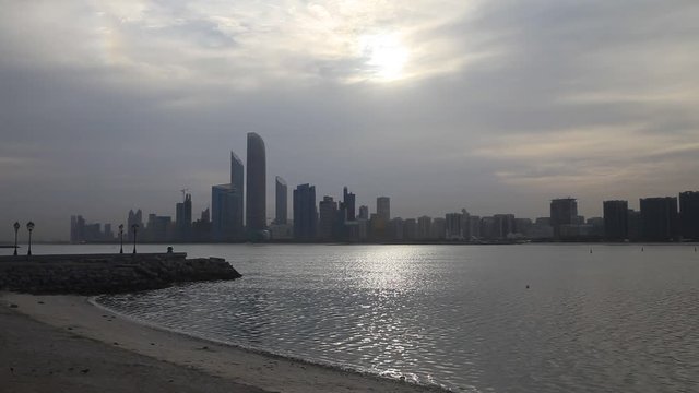 Abu Dhabi skyline with clouds at the sunrise. Establishing shot.