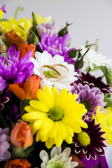 Wedding rings on a bright spring bouquet of the bride
