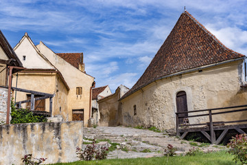 Fototapeta na wymiar Spring view of the Rasnov citadel inner countryard, in Brasov county (Romania), with beautiful medieval stone houses on the main street