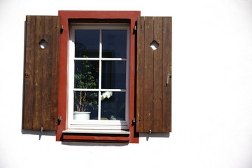 Naklejka na ściany i meble Nostalgisches Fenster / In einem nostalgischen Fenster mit geöffneten Fensterläden stehen Zimmerpflanzen.