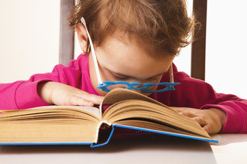 tired of reading little baby girl fell asleep on a book (Knowledge, education, reading, learning concept)