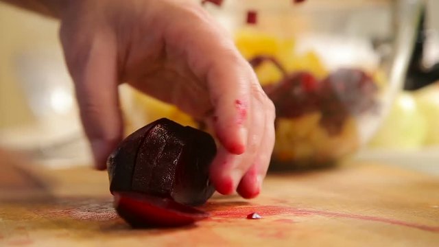Cutting boiled beetroot on a wooden board