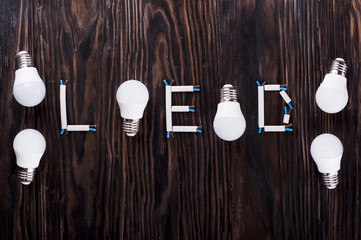 Led lamps lie on a wooden table.
