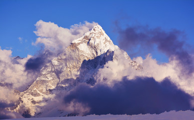 Beautiful evening view of the covered with clouds Mt. Ama Dablam. Sagarmatha national park, Nepal.