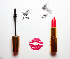 Red lipstick, mascara for the eyes imprint of the lips and an ink-painted eyes on a white background