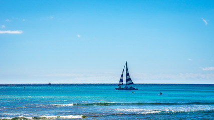 Sail Boat in the Pacific Ocean just off the coast at the famous Waikiki beach of the Hawaiian...
