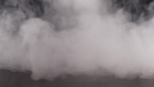 Strong white smoke on the black background slow motion