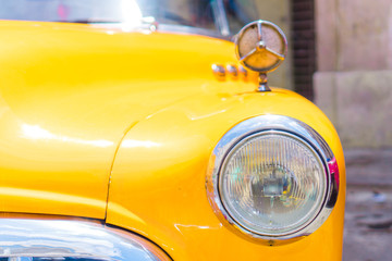 Closeup of yellow classic vintage car in Old Havana, Cuba