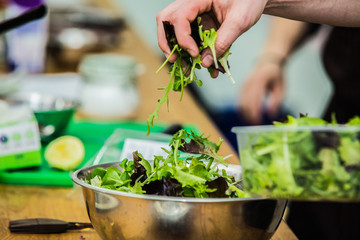 The chef in the kitchen prepares healthy food with vegetables.