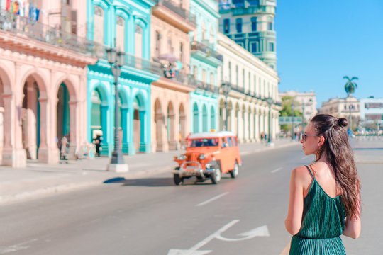 Happy woman in popular area in old Havana, Cuba. Young girl traveler background colorful houses