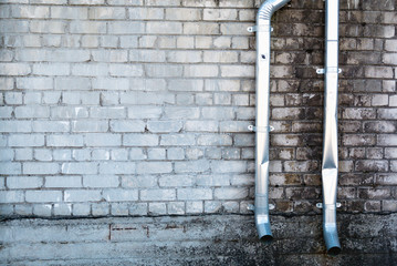 White brick wall and metal pipes