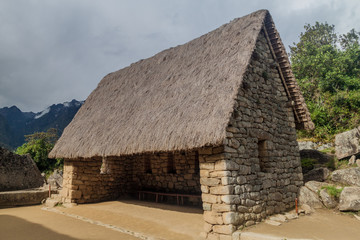 Fototapeta na wymiar House near ceremonial rock at Machu Picchu ruins, Peru