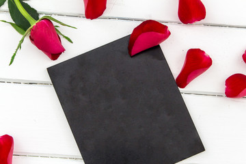 rote rose mit schwarzes schild auf holz hintergrund