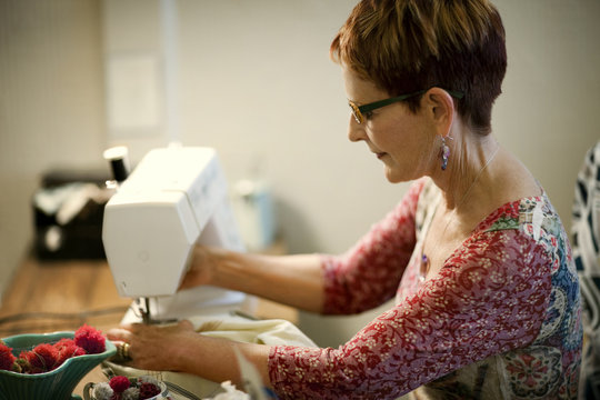 Middle aged woman using a sewing machine.