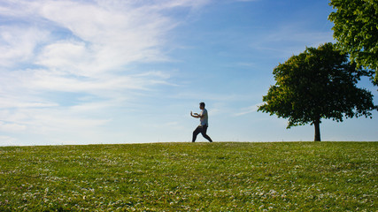 Lone man out in the countryside doing tai chi 