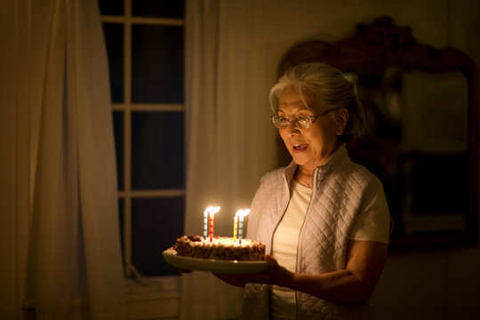 Senior woman holding birthday cake