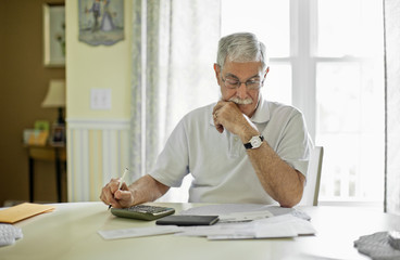 Stressed senior man calculating his home finances.